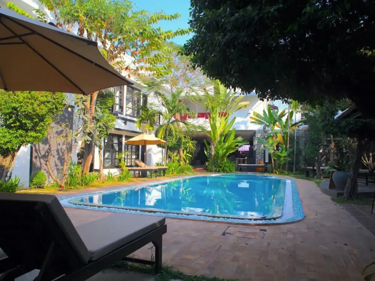 The Prana Hotel pool by day, lined with loungers and palm trees